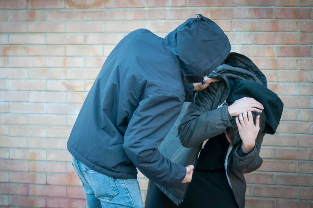 A person being aggressively confronted, representing the situation of being charged with menacing or threatening behavior in Binghamton, New York